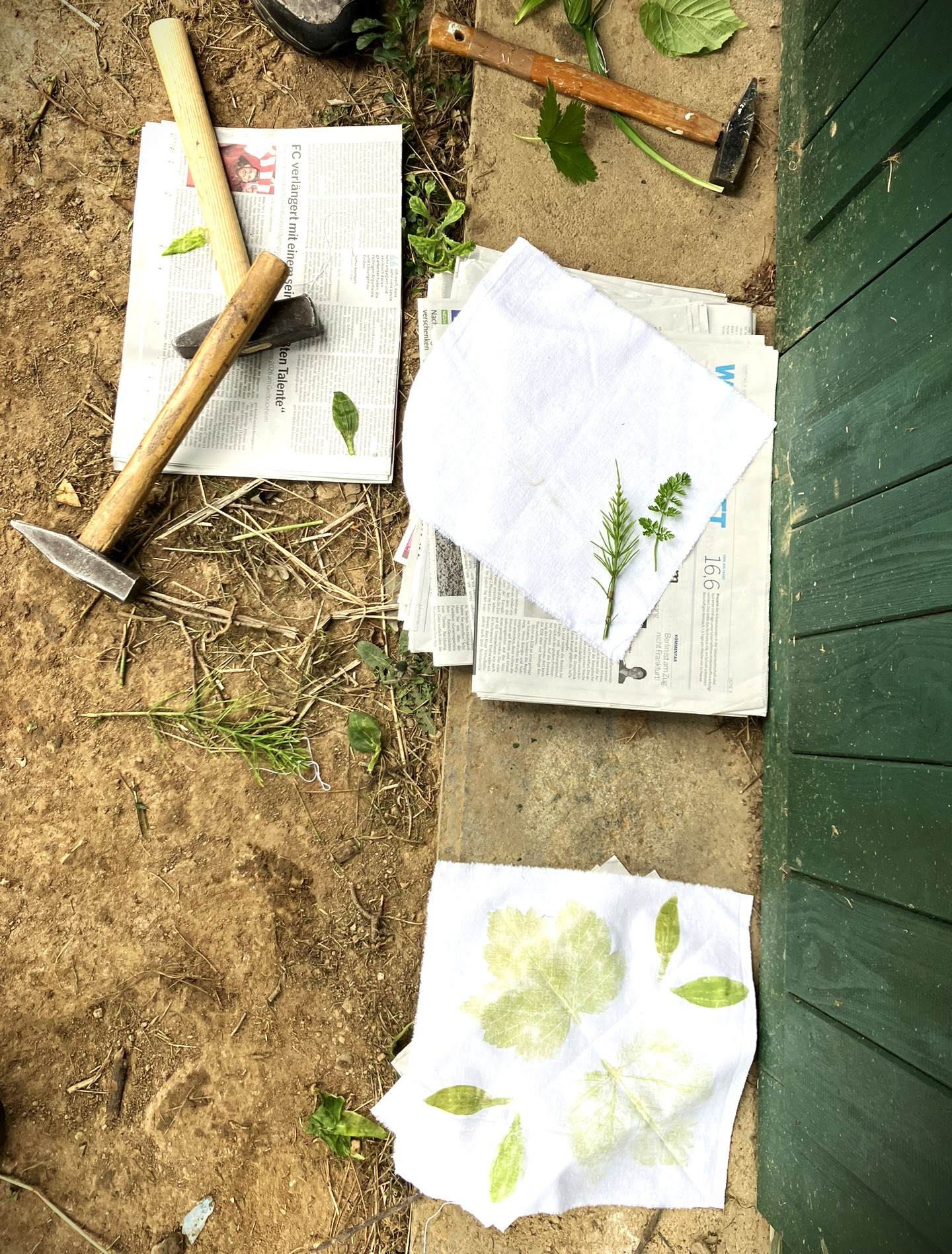 Drucken mit Pflanzenfarben beim Kräuterpädagogik-Praxisworkshop: Pflanzenteile werden zwischen Stofflagen gelegt. Dann wird der Pflanzensaft in den Stoff gehämmert.